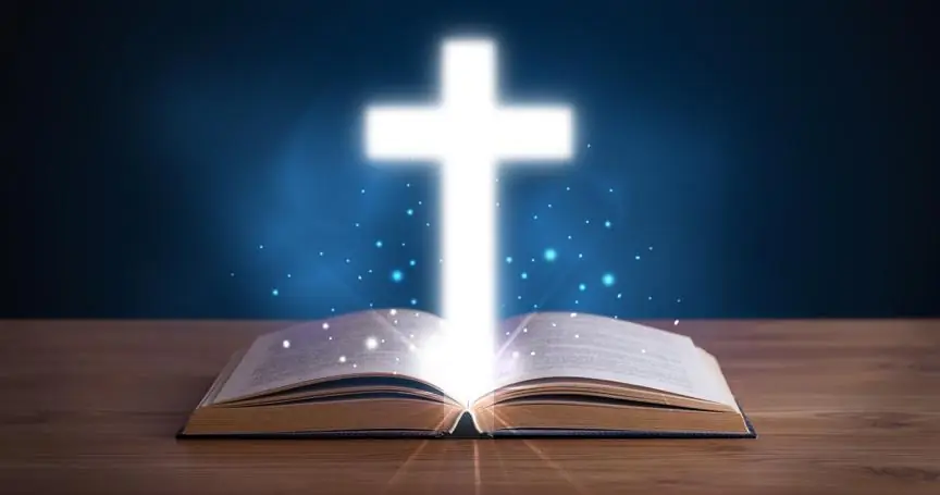 Open Holy Bible with Glowing Cross in the Middle